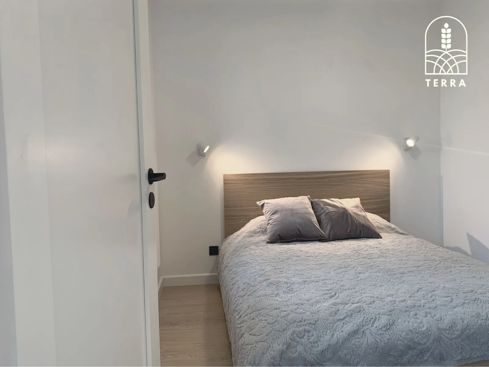 Wall lamps and the oak headboard — Terra House, Ventspils